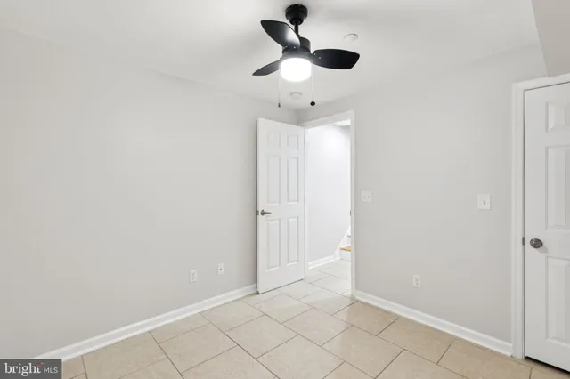 an empty room with fan and windows