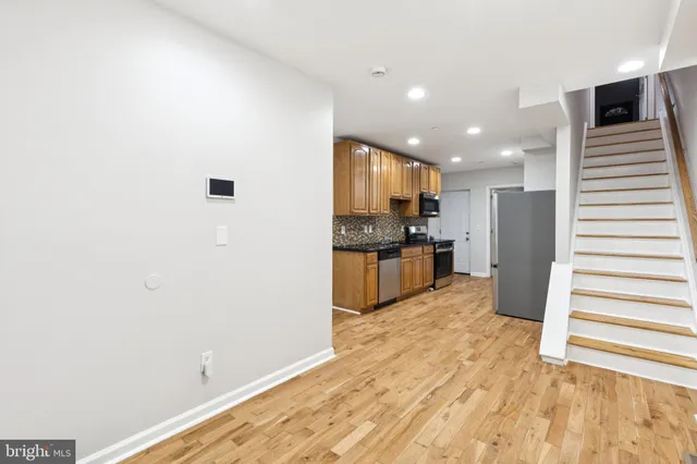 a view of a kitchen with wooden floor and staircase