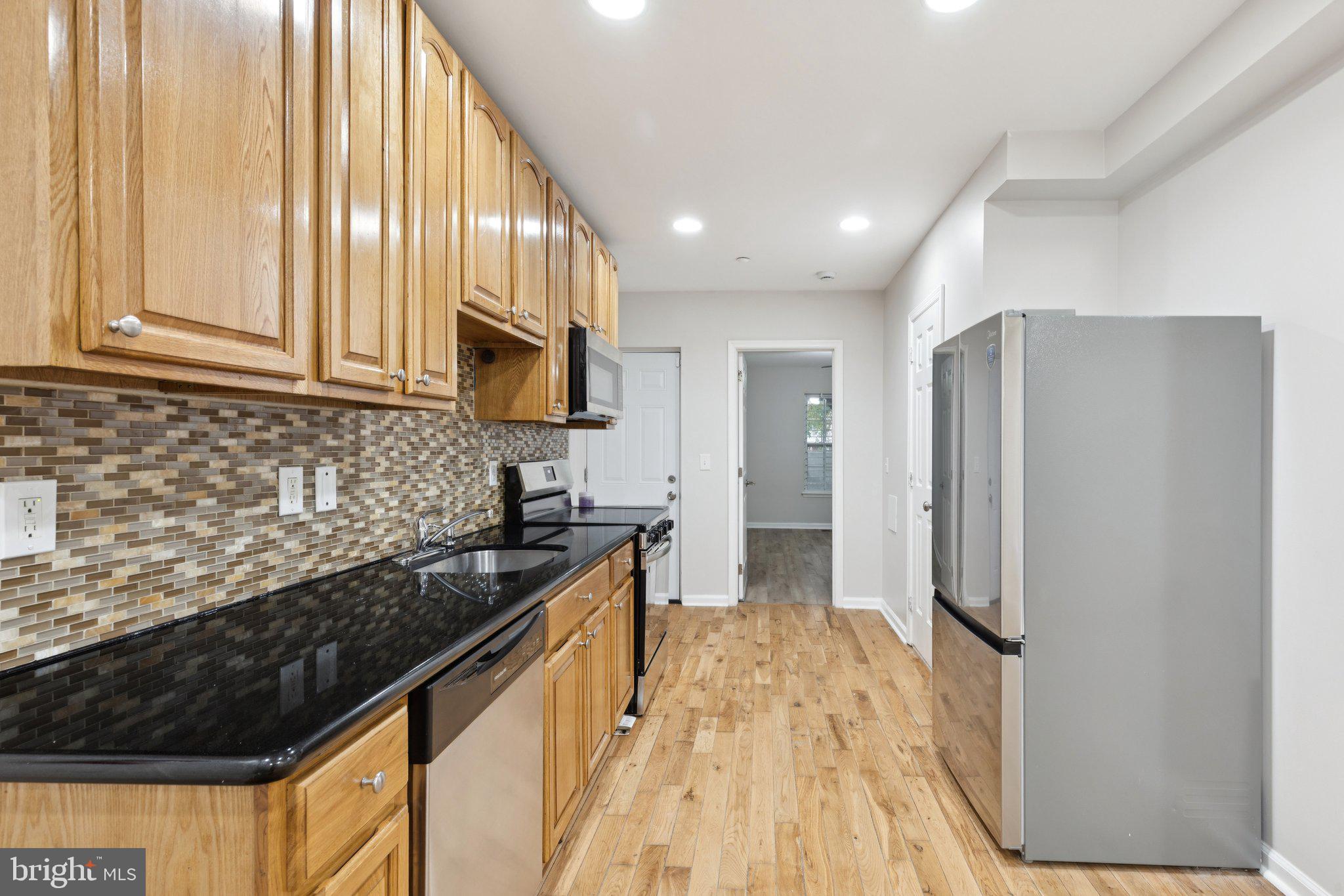 1931 North Uber Street, Unit 1 Philadelphia, PA 19121 - Photo 5 of 26 a kitchen with stainless steel appliances granite countertop a refrigerator and a sink