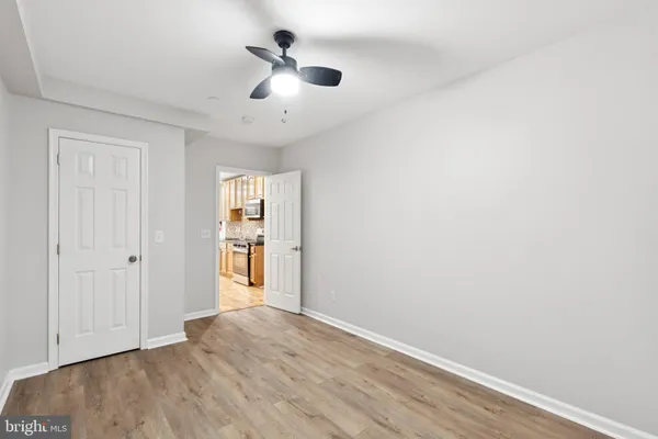 a view of empty room with wooden floor and ceiling fan