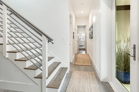 a view of a hallway with wooden floor and staircase