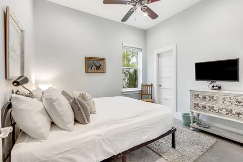 a bedroom with a bed tv and couch