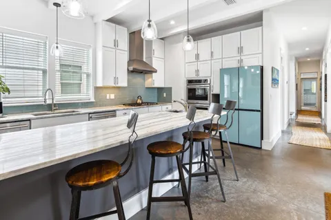 a kitchen with stainless steel appliances granite countertop a sink a stove and a refrigerator