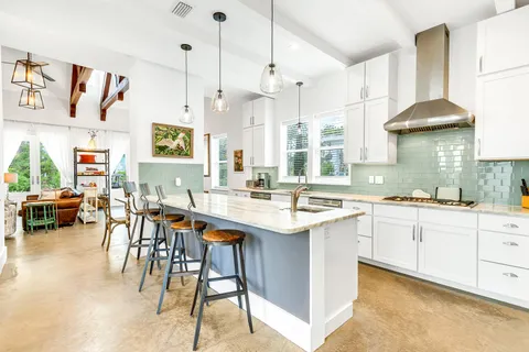 a kitchen with stainless steel appliances a table and chairs in it