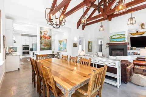 a dining room with stainless steel appliances a dining table and chairs with wooden floor