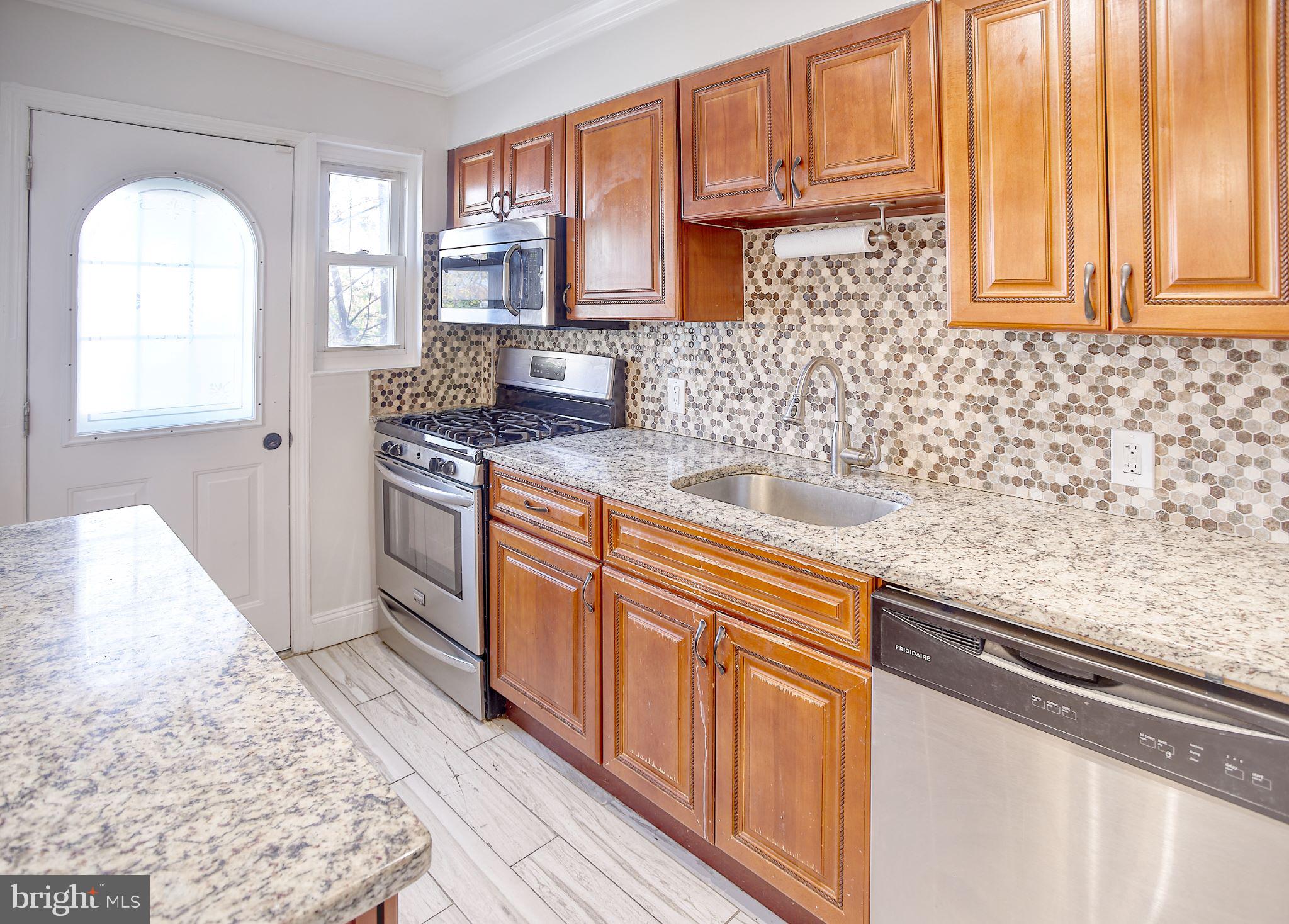 1029 Stamford Road Baltimore, MD 21229 - Photo 2 of 17 a kitchen with stainless steel appliances granite countertop a stove a sink and a microwave