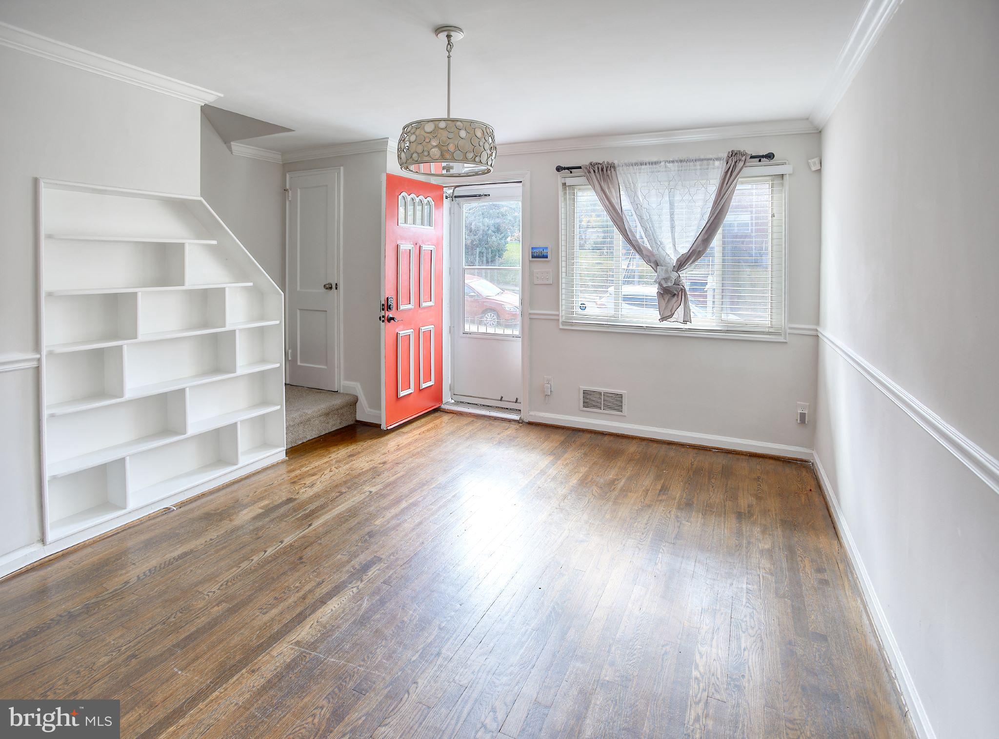 1029 Stamford Road Baltimore, MD 21229 - Photo 7 of 17 a view of an empty room with wooden floor and window