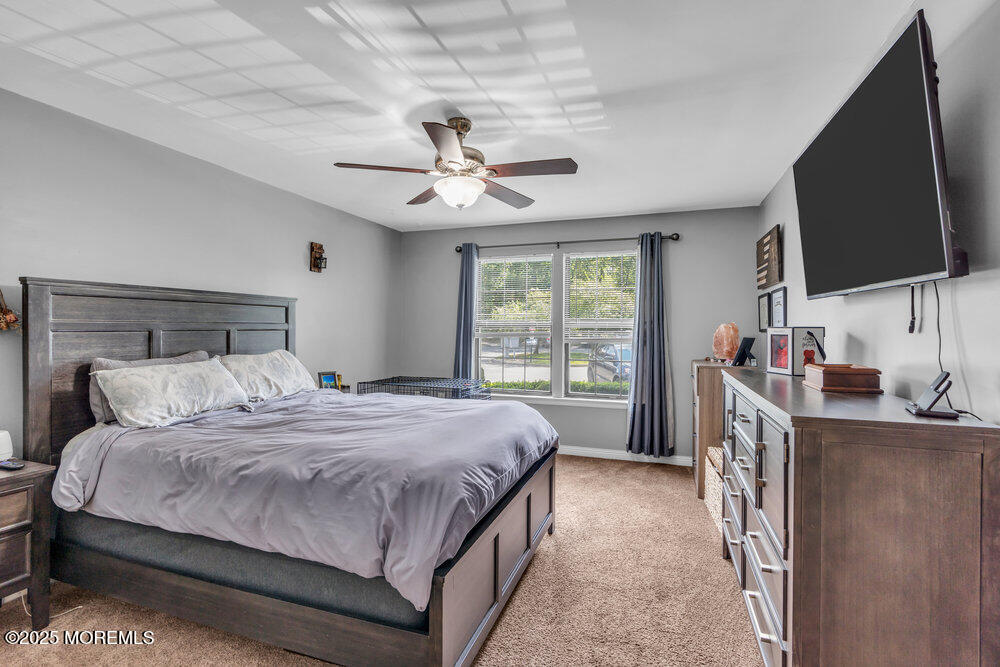 1506 Jasmine Court Jackson, NJ 08527 - Photo 12 of 20 a bedroom with a large bed a flat tv screen and a dresser