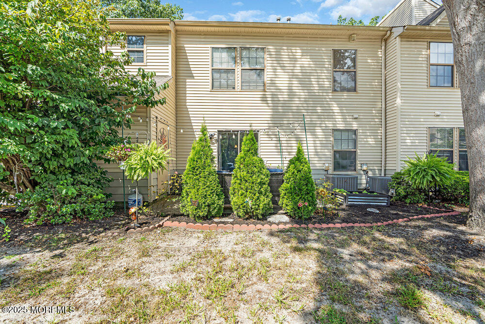 1506 Jasmine Court Jackson, NJ 08527 - Photo 19 of 20 a view of a house with potted plants and a bench in front of door