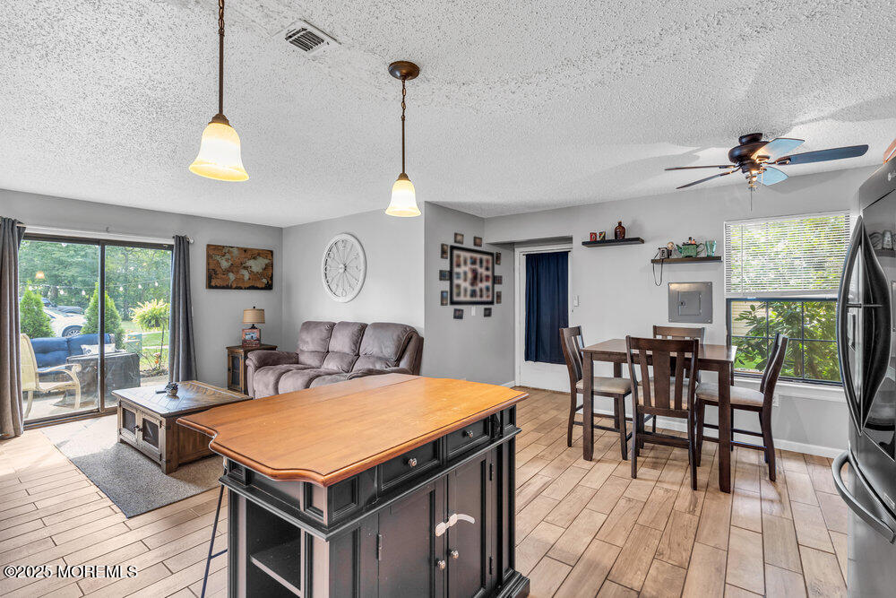 1506 Jasmine Court Jackson, NJ 08527 - Photo 10 of 20 a living room with stainless steel appliances granite countertop furniture a rug chairs and a chandelier