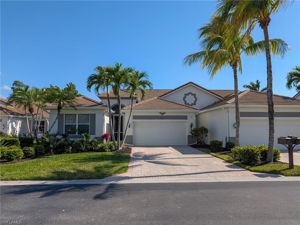 a front view of a house with a garden and palm trees