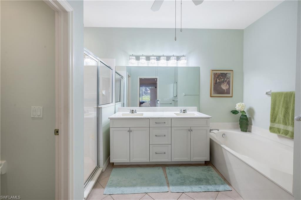 917 Fairhaven Court, Unit 29 Naples, FL 34104 - Photo 16 of 40 a spacious bathroom with a double vanity sink a mirror and a bathtub