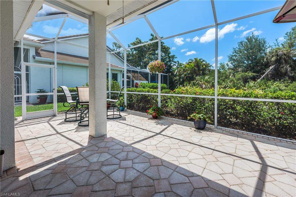 917 Fairhaven Court, Unit 29 Naples, FL 34104 - Photo 23 of 40 a view of a chair and table in the patio and a yard