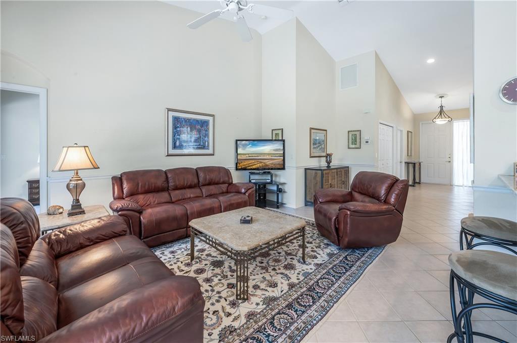 917 Fairhaven Court, Unit 29 Naples, FL 34104 - Photo 5 of 40 a living room with furniture a large window and a lamp