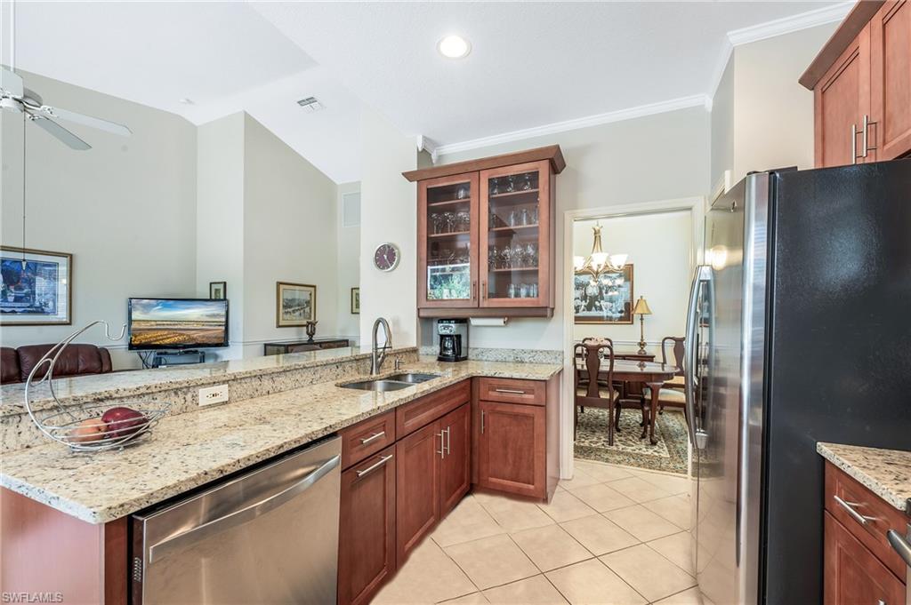 917 Fairhaven Court, Unit 29 Naples, FL 34104 - Photo 10 of 40 a kitchen with stainless steel appliances granite countertop a sink stove and refrigerator