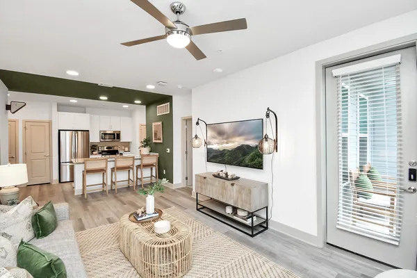 a living room with furniture a flat screen tv and a large window