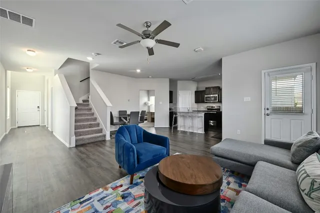a living room with furniture and a wooden floor