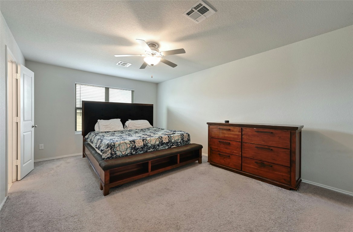 100 Comet Drive, Unit 1I Jarrell, TX 76537 - Photo 4 of 25 a bedroom with a bed and a chandelier