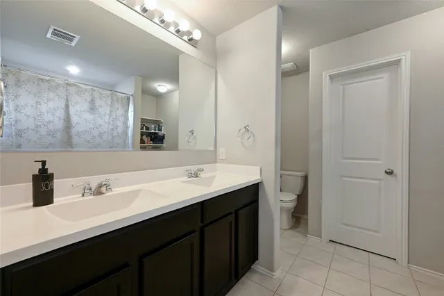 a bathroom with a double vanity sink and mirror