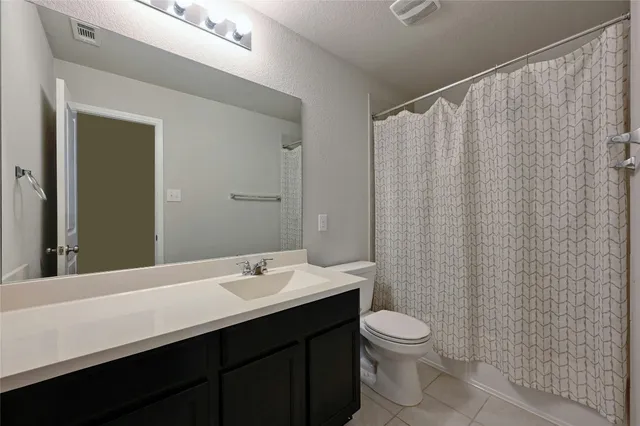 a bathroom with a double vanity sink toilet and a mirror