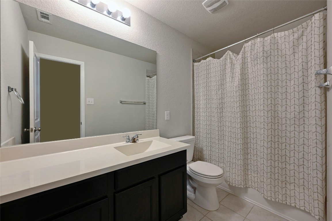 100 Comet Drive, Unit 1I Jarrell, TX 76537 - Photo 6 of 25 a bathroom with a double vanity sink toilet and a mirror