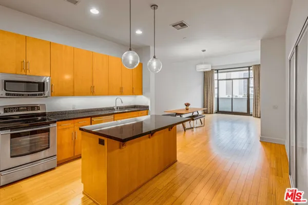 a kitchen with wooden floors and a large window