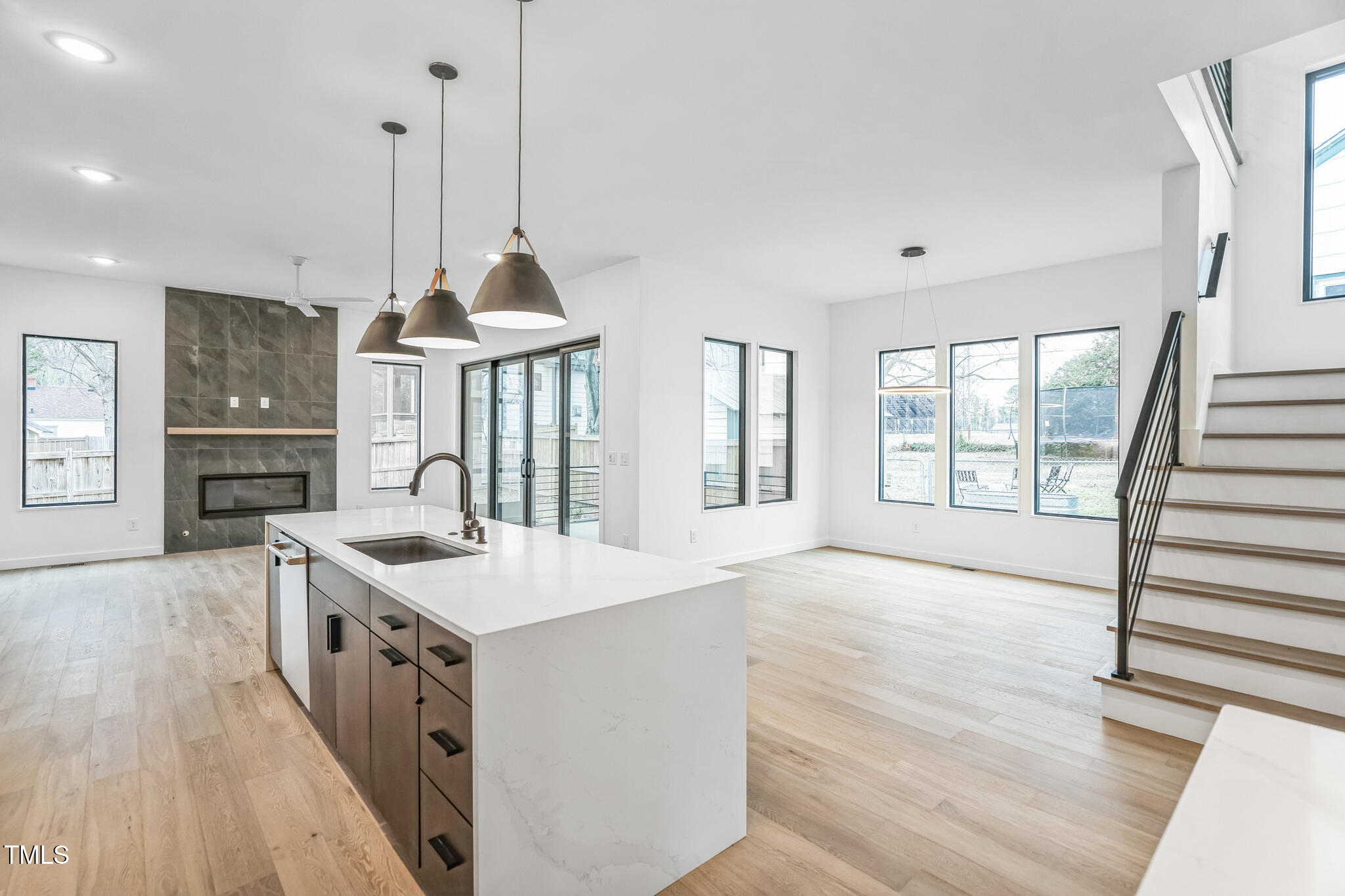 715 1/2 Van Buren Road Raleigh, NC 27604 - Photo 8 of 23 a open kitchen with kitchen island a stove a sink a center island and wooden floor