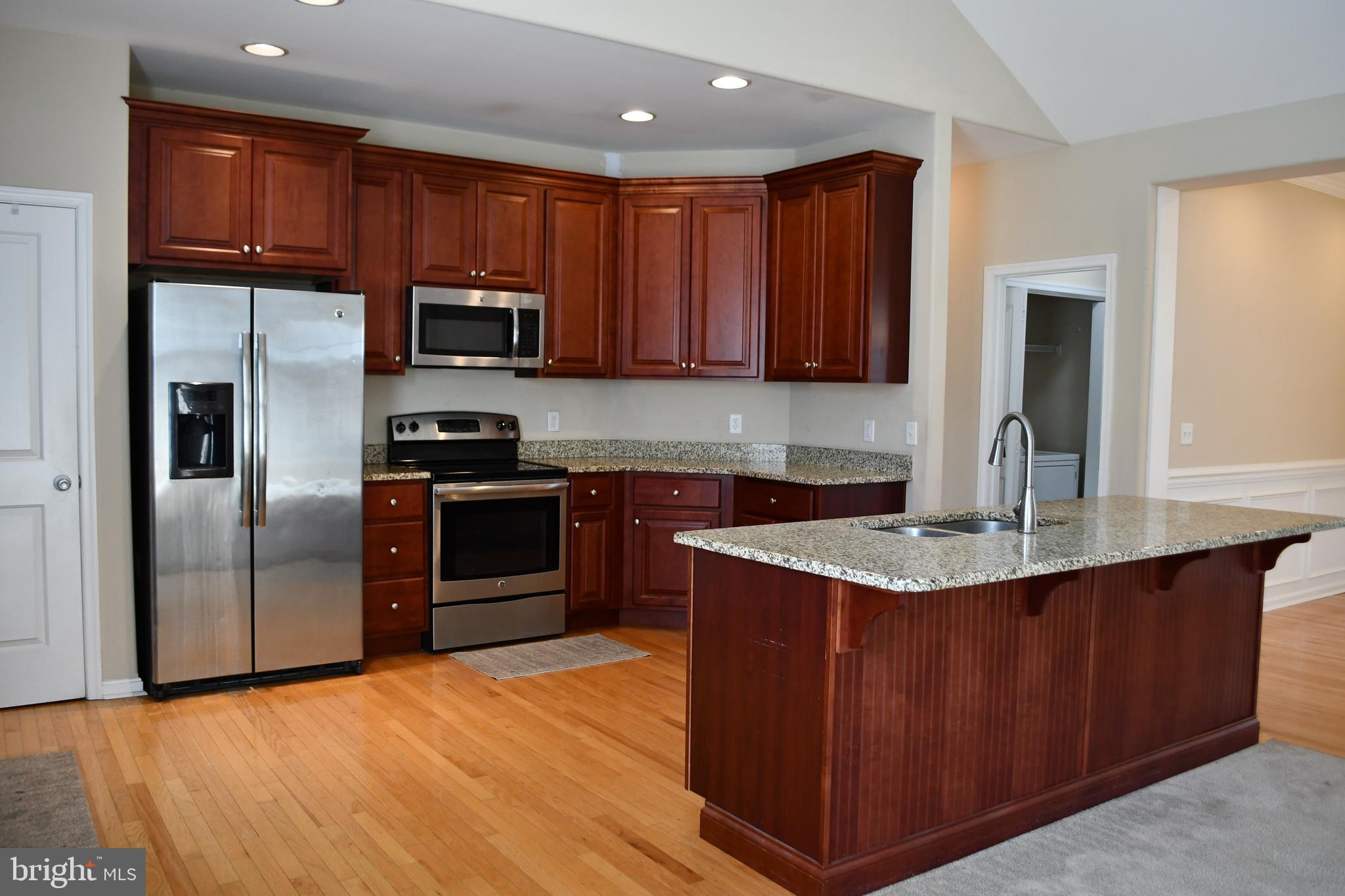 68 Split Oak Drive Felton, DE 19943 - Photo 5 of 22 a kitchen with stainless steel appliances granite countertop a refrigerator a sink dishwasher a stove with wooden cabinets and a stove
