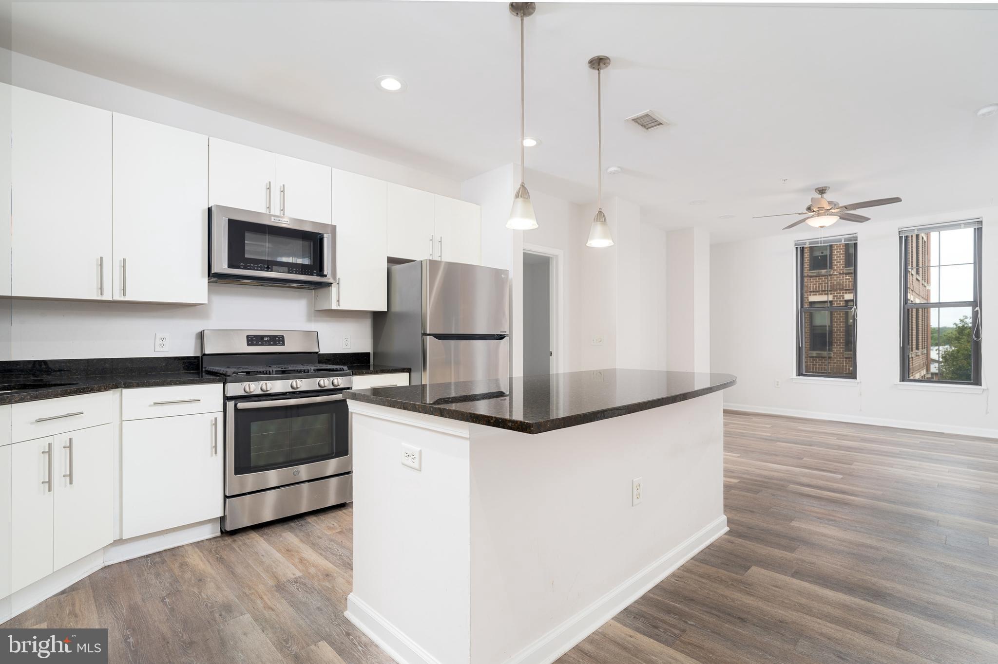 444 West Broad Street, Unit 401 Falls Church, VA 22046 - Photo 4 of 43 a kitchen with stainless steel appliances kitchen island a refrigerator sink and microwave