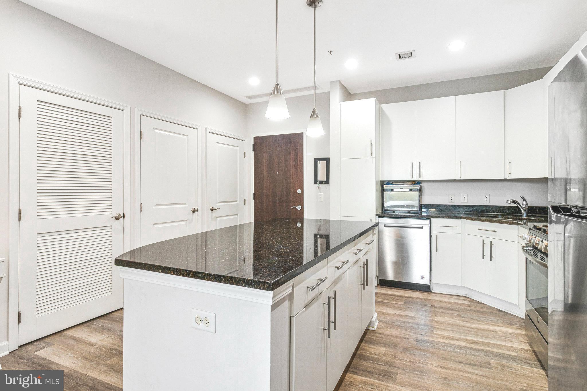 444 West Broad Street, Unit 401 Falls Church, VA 22046 - Photo 5 of 43 a kitchen with stainless steel appliances granite countertop a sink a stove and a refrigerator