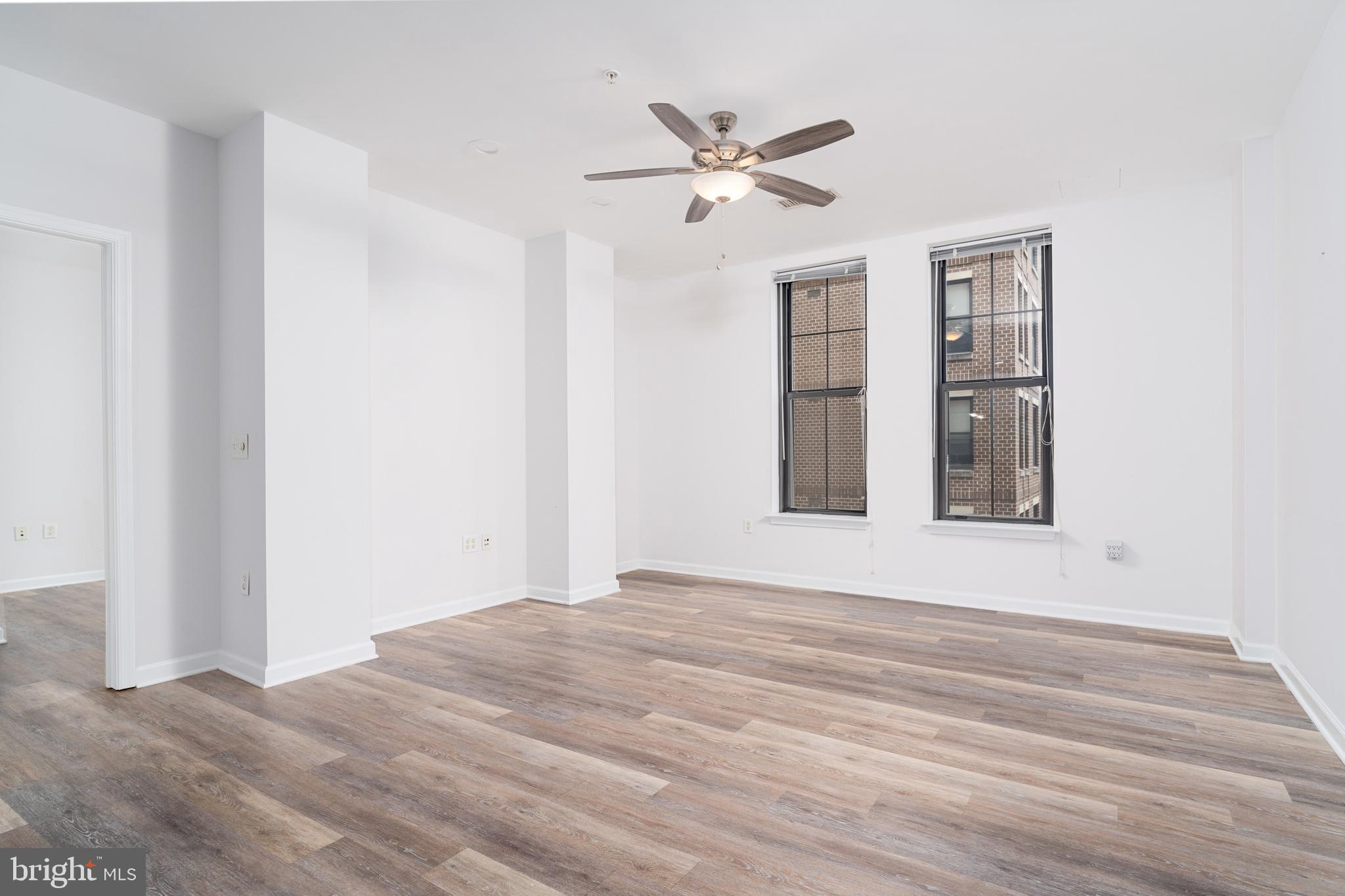 444 West Broad Street, Unit 401 Falls Church, VA 22046 - Photo 9 of 43 a view of an empty room with wooden floor and a window