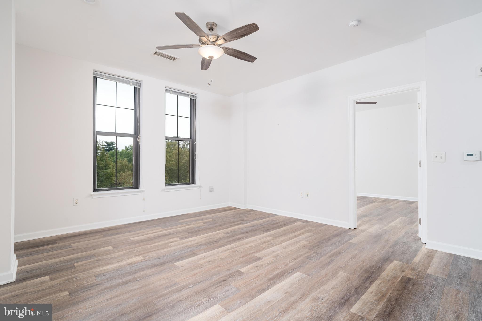 444 West Broad Street, Unit 401 Falls Church, VA 22046 - Photo 10 of 43 a view of an empty room with wooden floor and a window