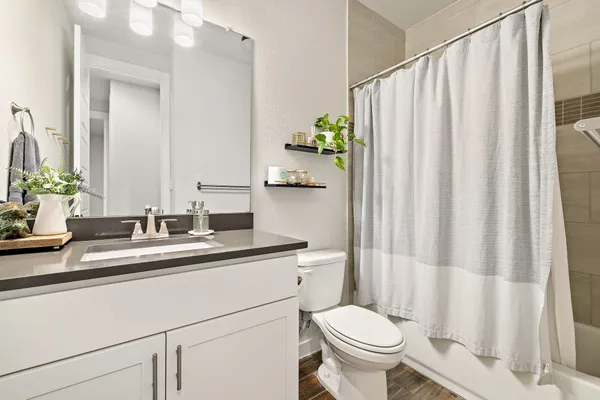a bathroom with a granite countertop sink and a toilet