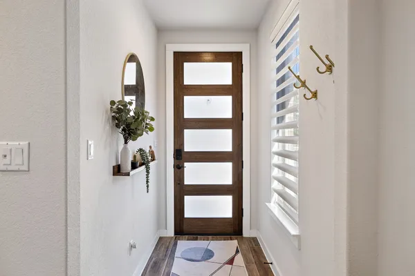 a view of a room that has a window and a white wooden door