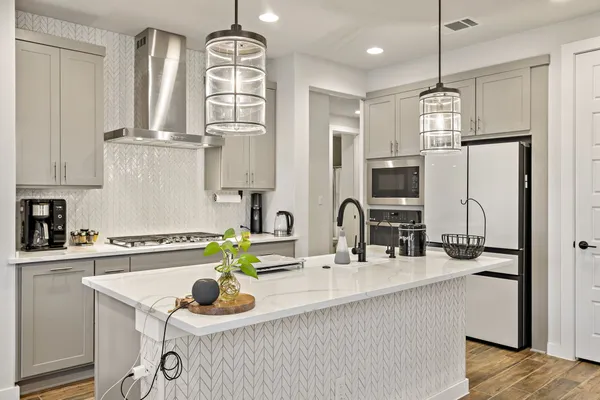a kitchen with stainless steel appliances a sink stove and refrigerator