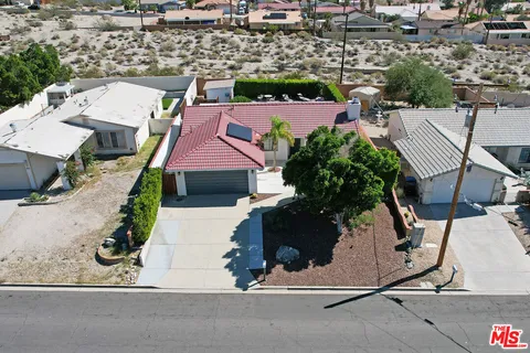 an aerial view of a house with a yard and parking space