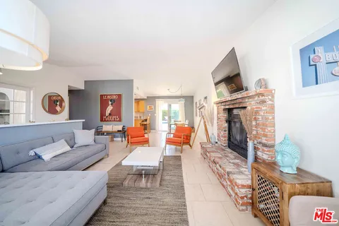 a living room with furniture a fireplace and a large window