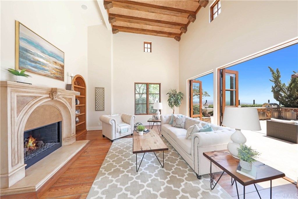 53 Overlook Drive Newport Coast, CA 92657 - Photo 14 of 28 The formal living room offers two story beamed ceilings, cozy fireplac, hardwood floors and two sets of French doors that open up to the patio.