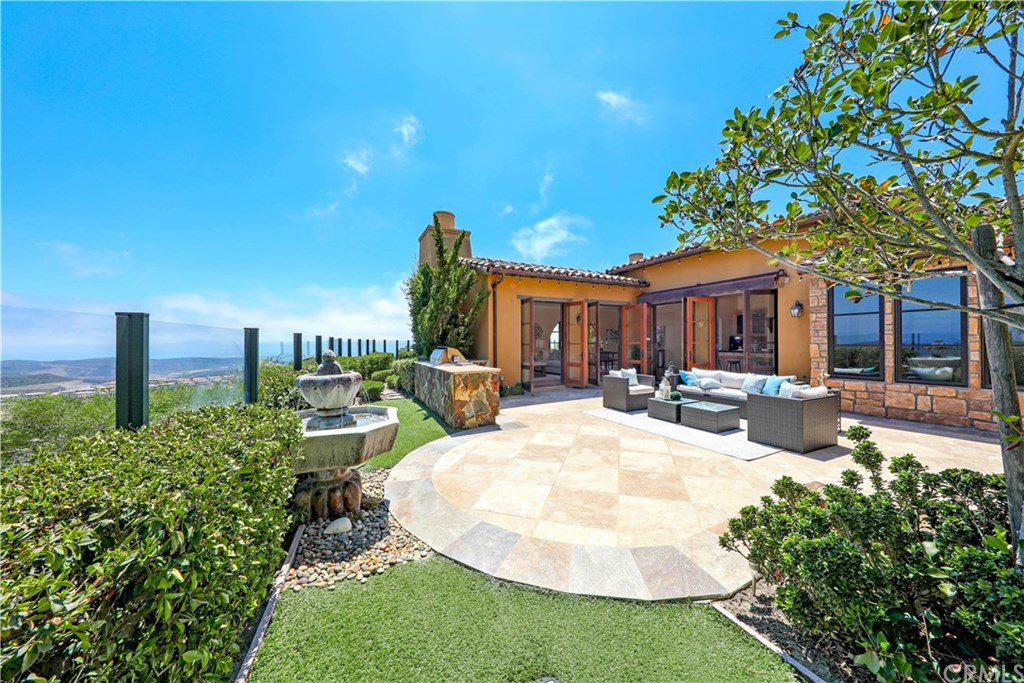53 Overlook Drive Newport Coast, CA 92657 - Photo 24 of 28 Sunny and Private Travertine tiled side yard features fountain, built in BBQ, synthetic grass and endless views of the hills and valleys of Newport Coast