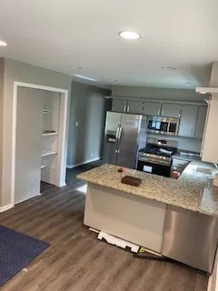 a large kitchen with a large window and stainless steel appliances