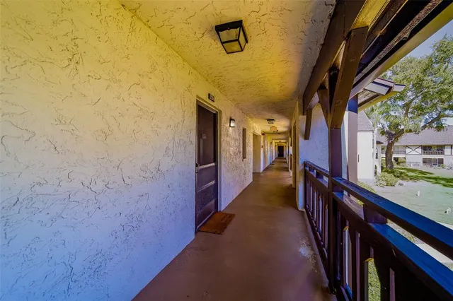 a hallway with wooden floor and stairs