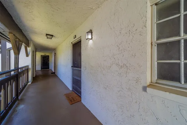 a view of a hallway with living room and wooden floor