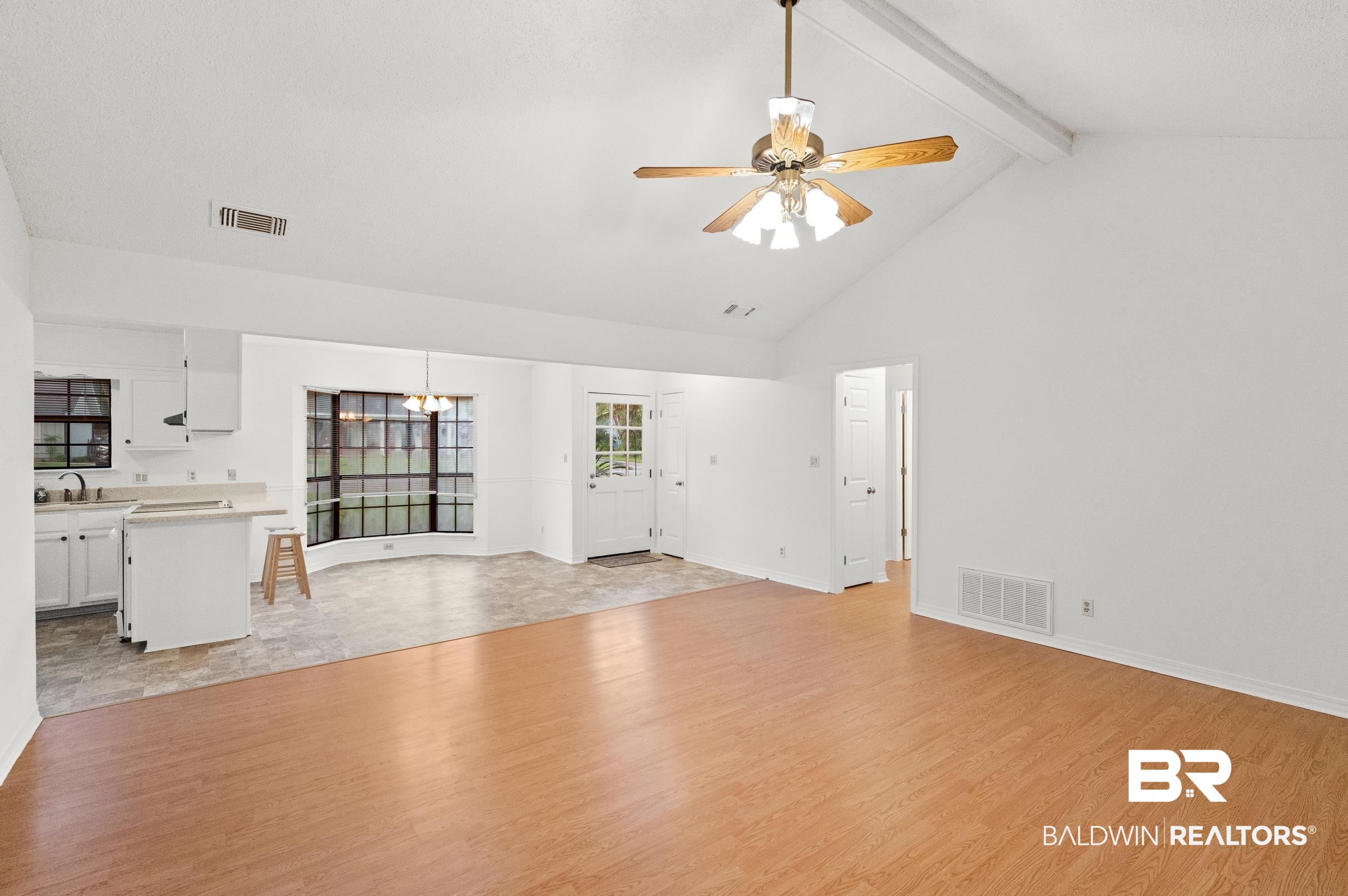 128 Dunbar Loop Daphne, AL 36526 - Photo 7 of 39 Unfurnished living room featuring ceiling fan, light hardwood / wood-style floors, lofted ceiling with beams, and sink