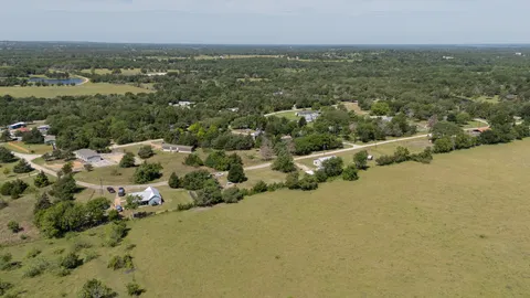 an aerial view of residential houses with outdoor space and trees