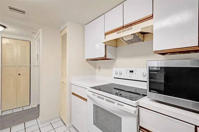 a kitchen with white cabinets and white appliances