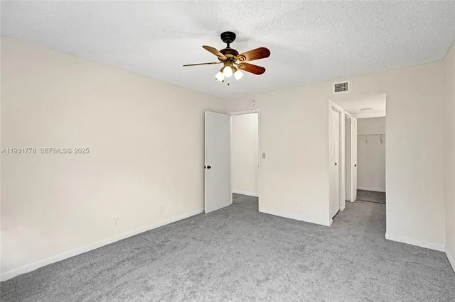 a view of an empty room with a ceiling fan
