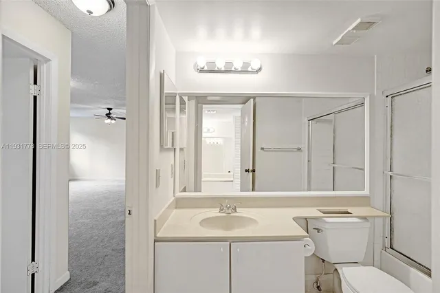 a bathroom with a sink toilet vanity and shower