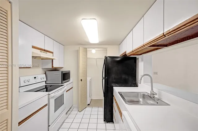 a kitchen with appliances a sink and cabinets