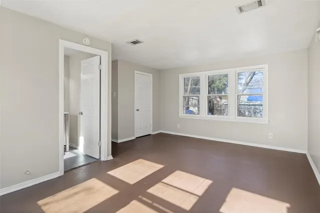 an empty room with windows and closet
