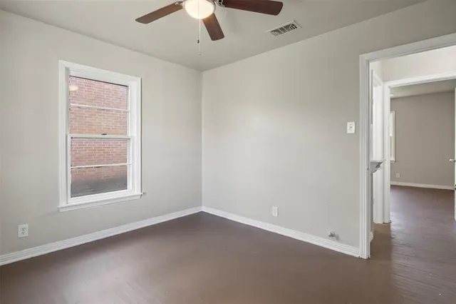 an empty room with a window and a ceiling fan